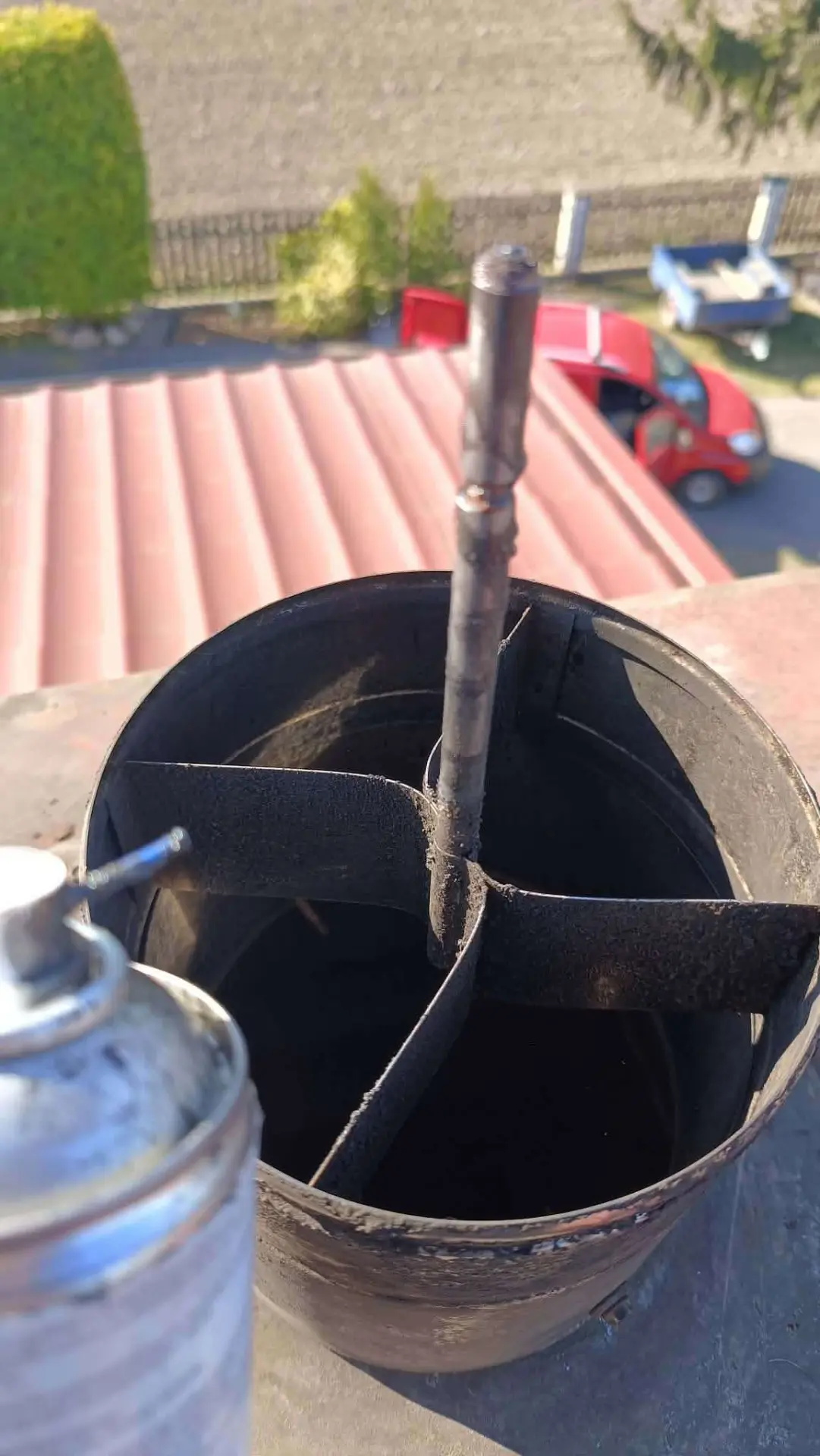 Czyszczenie nasady kominowej mechaniczną szczotką na dachu